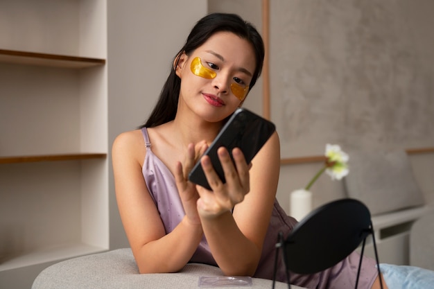 Full shot woman using eye patches