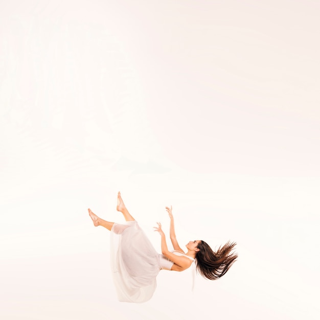 Full shot woman in white dress floating