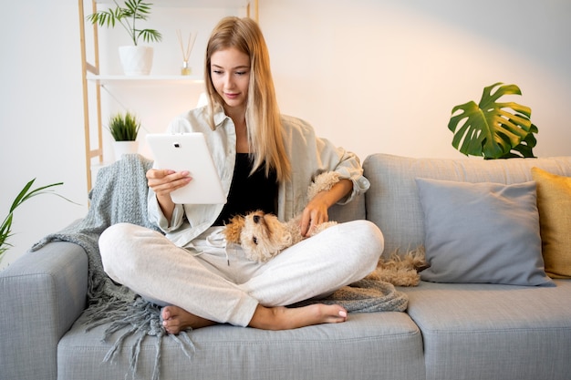 Full shot woman with tablet and dog