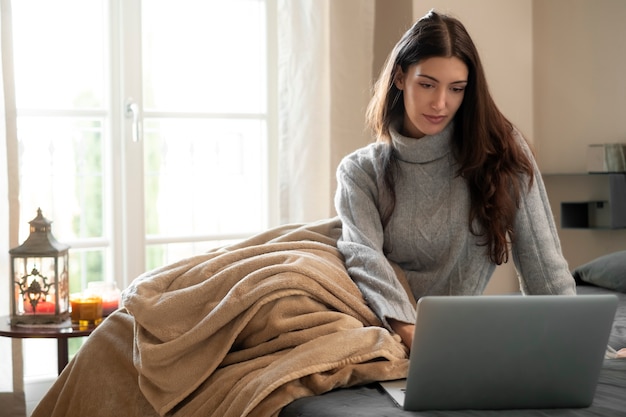 Full shot woman working on laptop