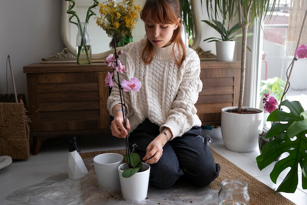 Full shot young woman with beautiful orchid