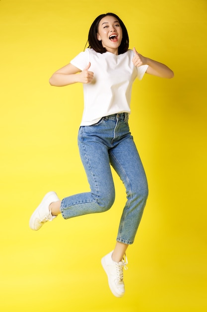 Full size of happy young asian woman jumping from joy