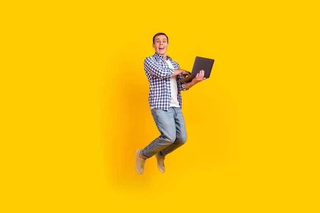 Full size photo of concetrated man jump work computer search sales discounts isolated over shine color background