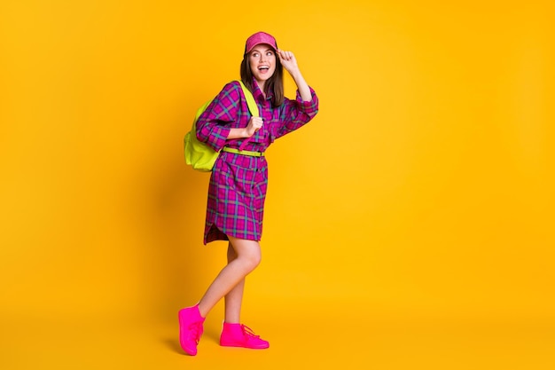 Photo full size photo of nice charming teen girl wear pink headwear dress sneakers green strap bag isolated on yellow color background