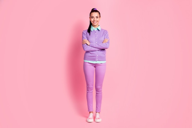 Full size photo of pretty charming girl stand isolated over pink color background cross hands wear violet outfit