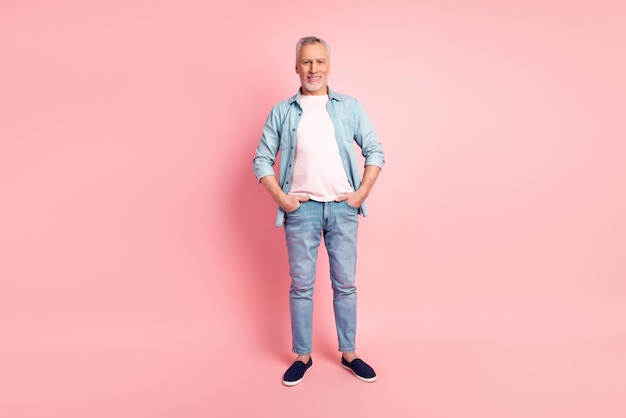 Full size photo of senior man confident good mood standing hands in pocket isolated over pink color background.