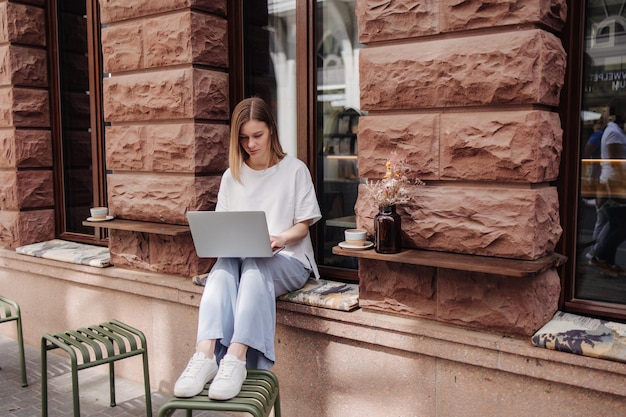 Full view of blonde caucasian woman working on laptop