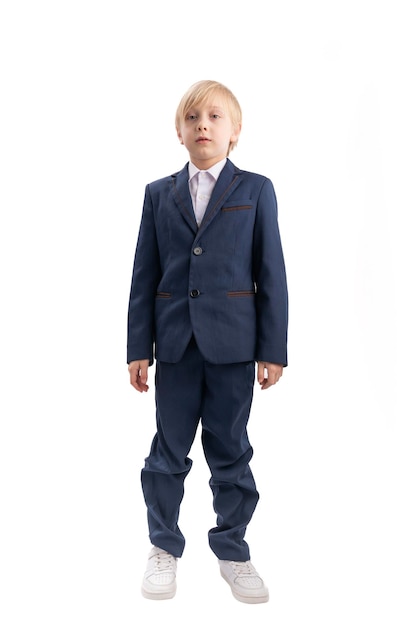 Fulllength portrait of eightyearold boy in school uniform Isolation on white background Schoolboy in blue suit Vertical frame