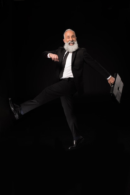 Fulllength shot of businessman in a suit cheerfully marching with his briefcase and laughing