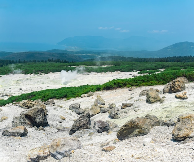 Fumarole field on the slope of Mendeleev volcano on Kunashir island overlooking the ocean in the haze