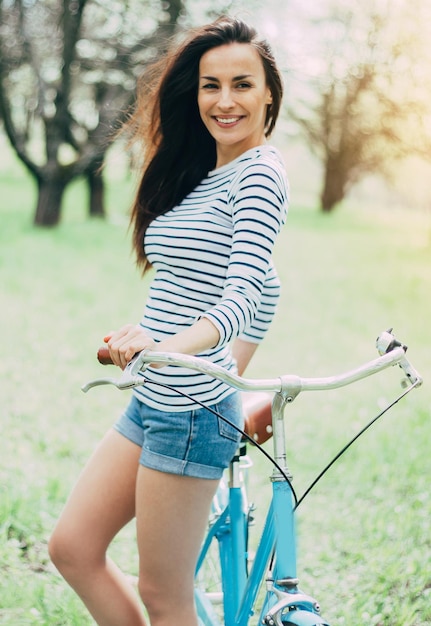 Fun day with bike Pretty gorgeous and happy woman with vintage bicycle in city park on the sunset