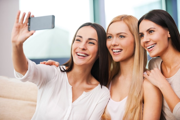 fun in focus. three beautiful young women making selfie and smiling 