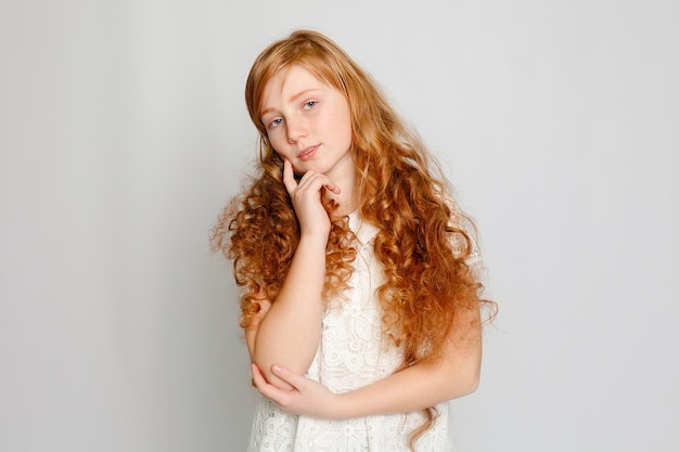 Fun Portrait of an Adorable Red Haired Girl on a Grey Background Beauty kid fashion cosmetics healthy hair Hairdresser makeup shampoo