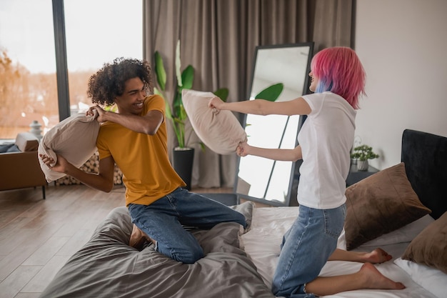 Fun Young couple having fun and fighting with pillows