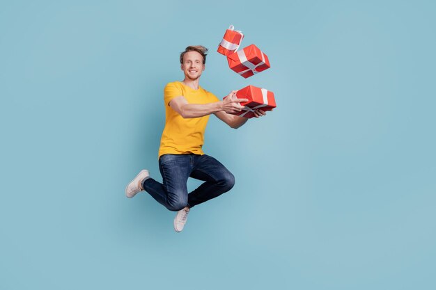 Funky crazy carefree guy jump hold pile present boxes wear casual clothes isolated on turquoise background