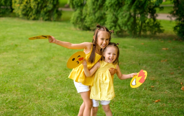 Funniest girls holding paper emoji images in hands