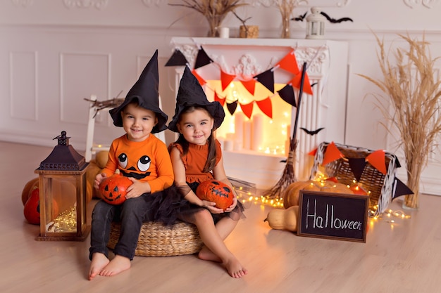 Funny baby boy and girl in halloween witch costumes