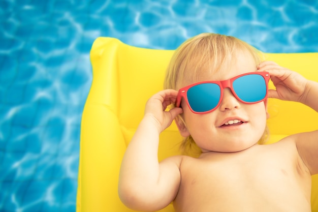 Funny baby boy on summer vacation Child having fun in swimming pool