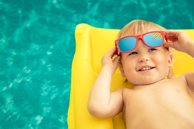 Funny baby boy on summer vacation Child having fun in swimming pool