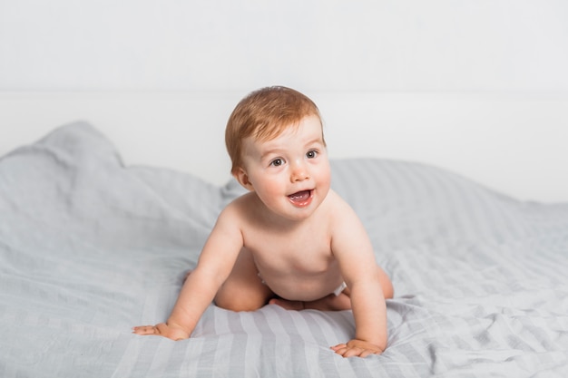 Funny blonde baby on a bed