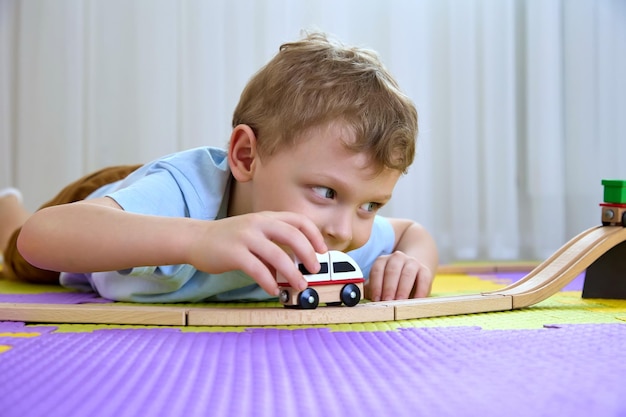 Funny boy 45 years old looks into the camera and plays with a train