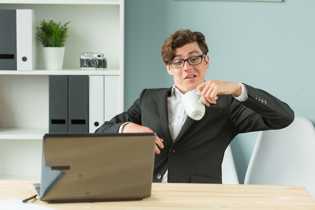 Funny businessman spilling tea in office