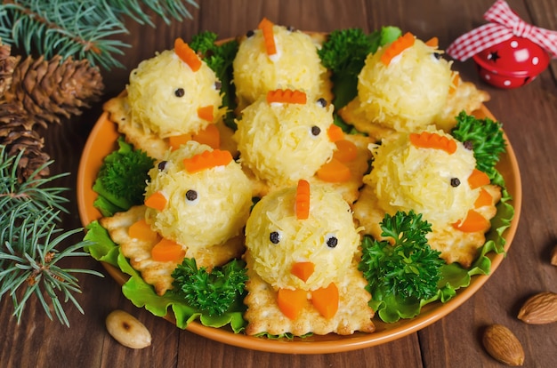 Funny chickens on the Christmas table with the symbol of 2017. Snack of cheese and almonds