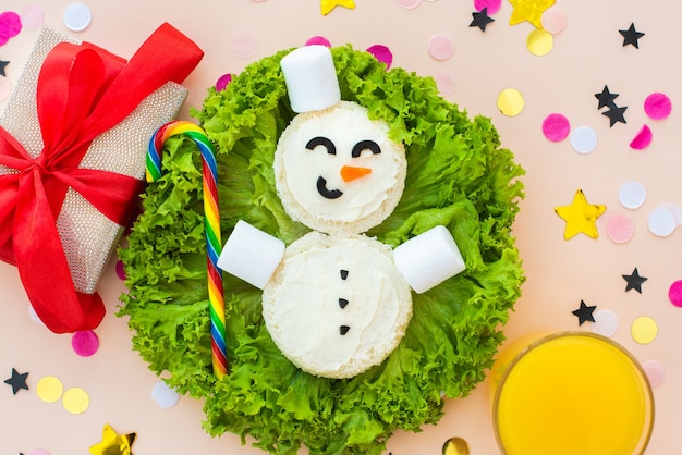 Funny Christmas breakfast, sandwiches, snowman, rainbow candy, marshmallows.