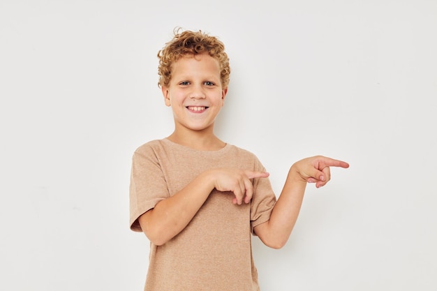 Funny curly boy in a white tshirt gestures with his hands