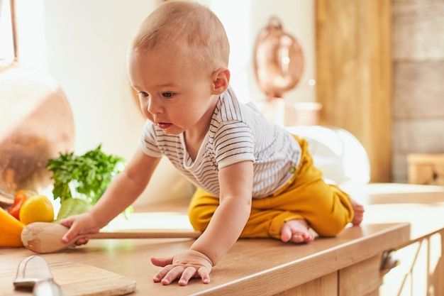 Funny cute boy toddler crawls around the kitchen