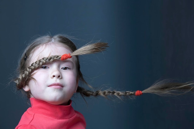 Funny cute girl with pigtails in the wind