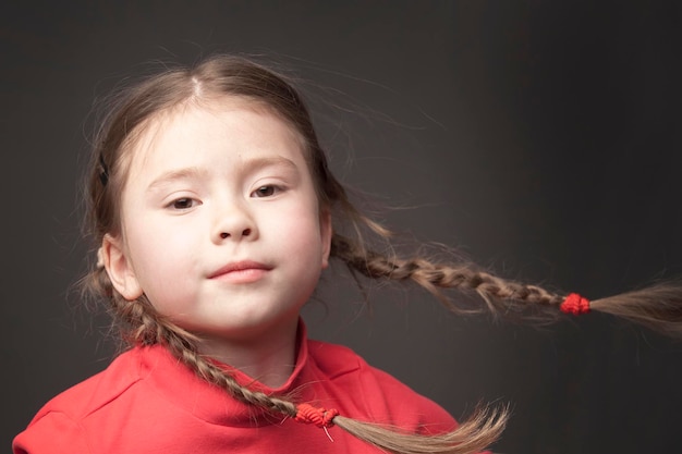 Funny cute girl with pigtails in the wind