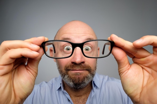 Funny european man looking through glasses Have problems with eyesight