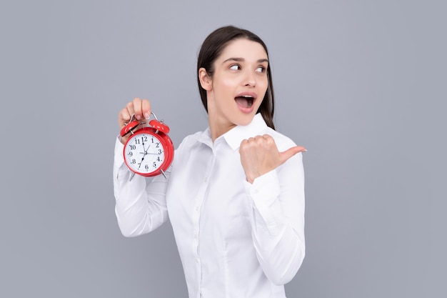 Funny excited woman at morning time holding alarm clock