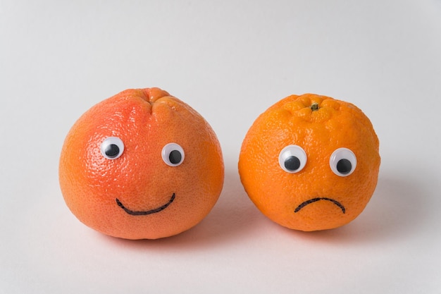 Funny food tangerines couple with eyes Funny and sad tangerines on a white background