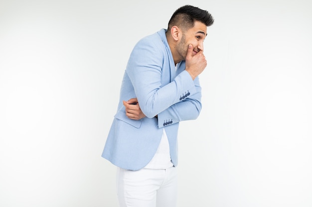 Funny gentleman covers his mouth with his hand on a white studio