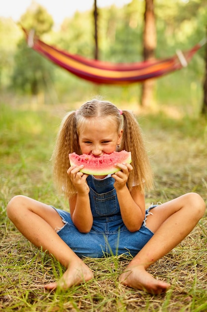 Funny girl eating watermelon in the park