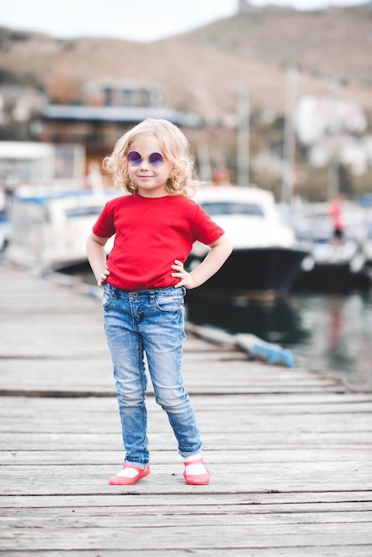 Funny girl wearing summer clothes outdoors over boats outdoors