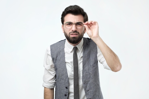 Funny good looking skeptical man in glasses looking at camera