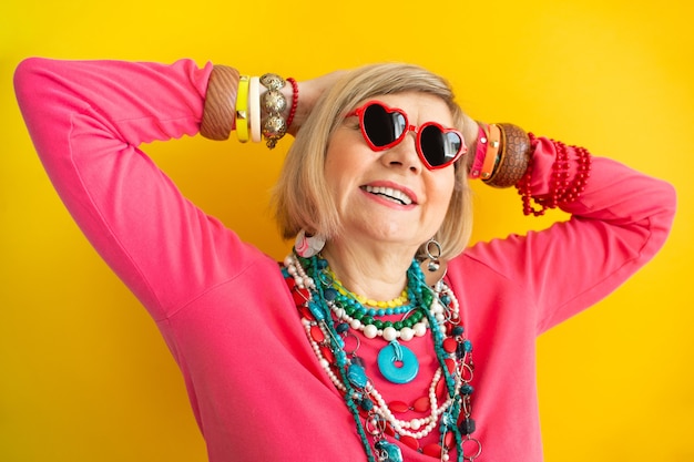 Funny grandmother portraits. Senior old woman having fun in stylish clothes, concepts about senior peopleon colored background.