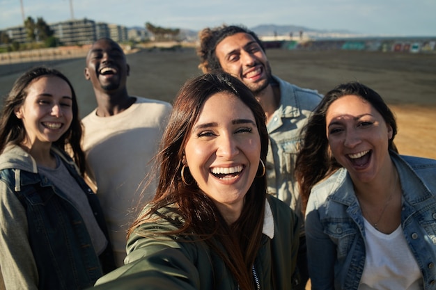 Funny group of fiends taking selfies at sunset