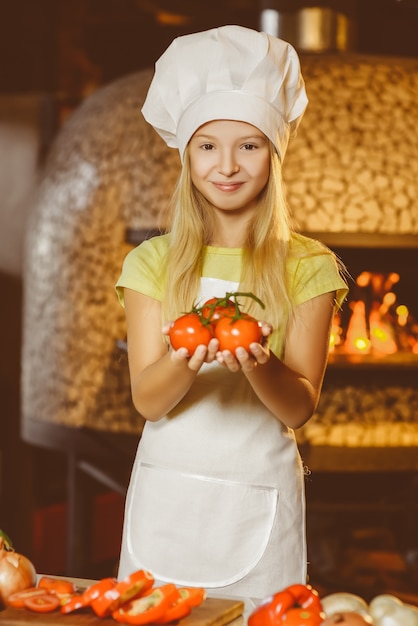 Funny happy chef girl cooking at restaurant kitchen