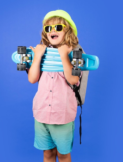 Funny happy kid in casual wear holding longboard looking happy and excited Studio isolated portrait