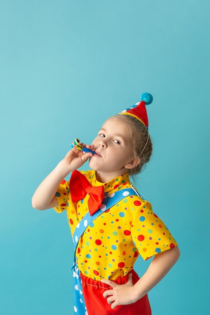 Funny kid clown against blue background Birthday and 1 April Fool's day concept