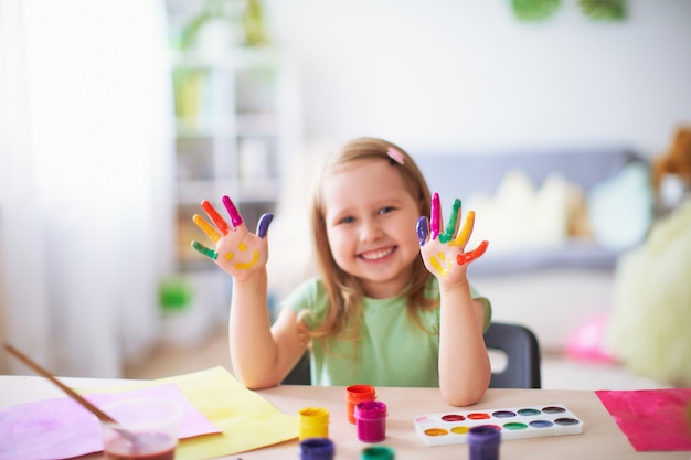 Funny kid show their palms the painted paint. 