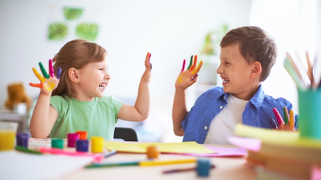 Funny kids show their palms the painted paint. 