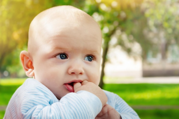 Funny little boy holding hands in mouth