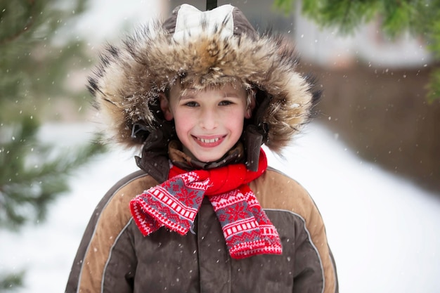 Funny little boy among the snowcovered Christmas trees Child in winter