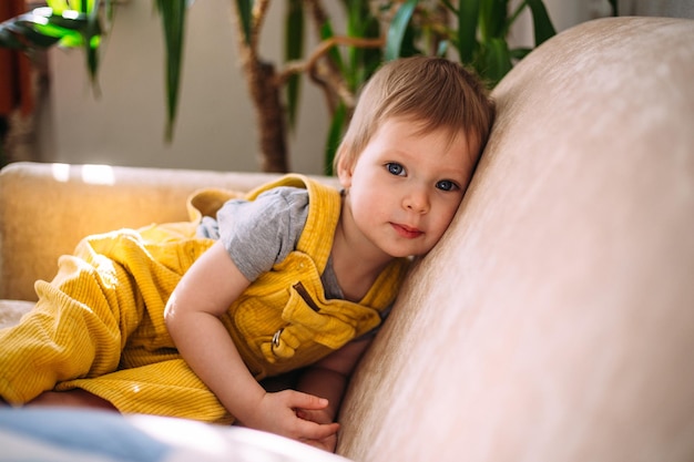 Funny little child is having fun playing with soft toys on the couch at home