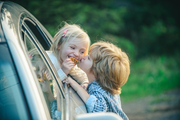 Funny little couple saying goodbye before car travel bye bye farewell concept little boy gives warm ...